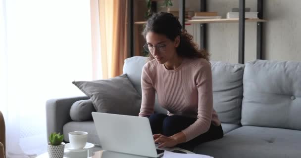 노트북을 사용하여 집에서 좋은 소식을 읽는 젊은 여자가 흥분 한 모습 — 비디오