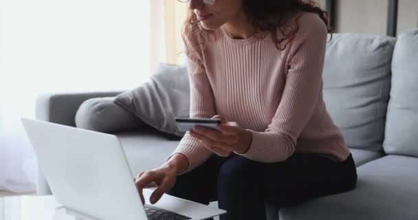 Feliz cliente femenino sosteniendo tarjeta de crédito pagando en línea en el ordenador portátil — Vídeos de Stock