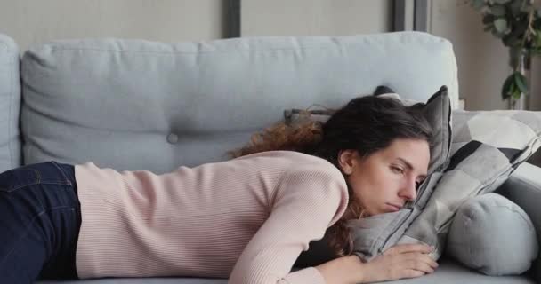 Wyczerpana lub znudzona młoda śpiąca kobieta upada na sofę — Wideo stockowe