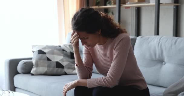 Inquiète jeune femme inquiète assise sur le canapé souffrant de stress — Video