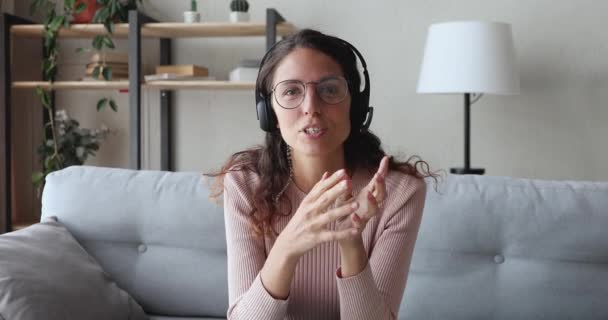 Šťastný mladý obchod žena na sluchátka mluvit s webovou kamerou — Stock video