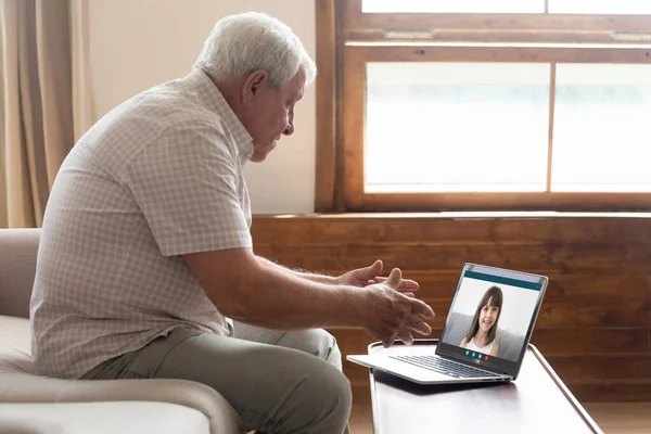 Senior man prata med leende barnbarn på videosamtal — Stockfoto