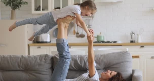 Mamá sana y pequeña hija practican el acro yoga en casa — Vídeo de stock