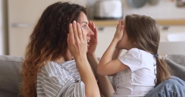Niedliche kleine Tochter umarmt glückliche Mutter beim gemeinsamen Kuscheln — Stockvideo