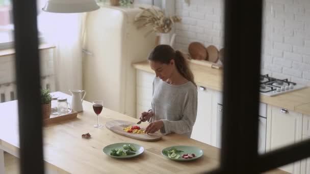 Señora milenaria positiva preparando comida sola en casa . — Vídeos de Stock