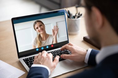 Genç çalışan koca, gülümseyen eşiyle çevrimiçi görüşme yapıyor.