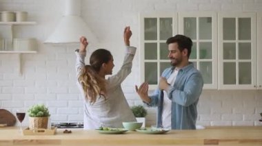 Mutlu genç aile çifti modern mutfakta birlikte eğleniyor..