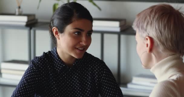 Улыбающаяся индийская деловая женщина разговаривает с коллегой в офисе — стоковое видео