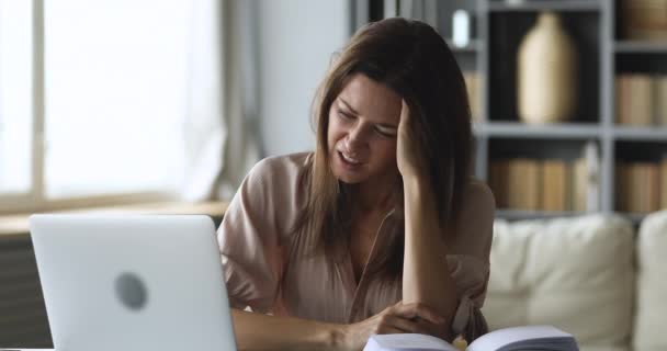 Mujer joven frustrada que sufre de dolor de cabeza debido al uso excesivo de la computadora . — Vídeos de Stock