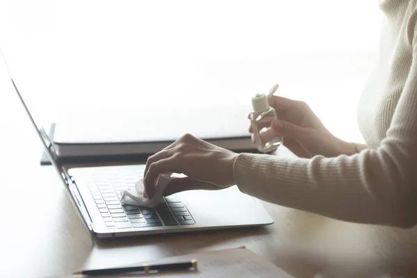 Mladá žena čištění notebook klávesnice s antiseptickým gel na ubrousku. — Stock fotografie