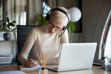 Odaklanmış iş kadını laptopta eğitim dersi dinliyor..
