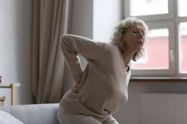 Yaşlı orta yaşlı kadın aniden keskin sırt ağrısı çekiyor..