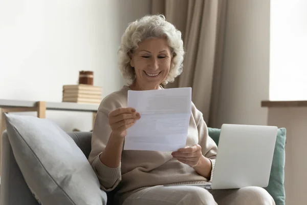 Kağıt okuyan mutlu orta yaşlı kadın. — Stok fotoğraf