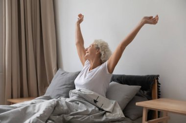 Mutlu orta yaşlı kadın uyandıktan sonra geriliyor..