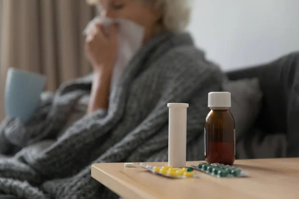 Cerrar botellas de vidrio y plástico con pastillas en la mesa . — Foto de Stock