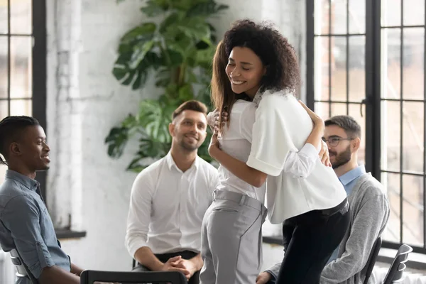 African American and caucasian women embracing at group therapy session. — Stock Photo, Image