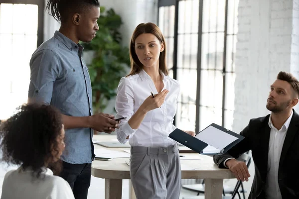 Femme d'affaires sérieuse confiante en costume debout dire aux employés divers . — Photo