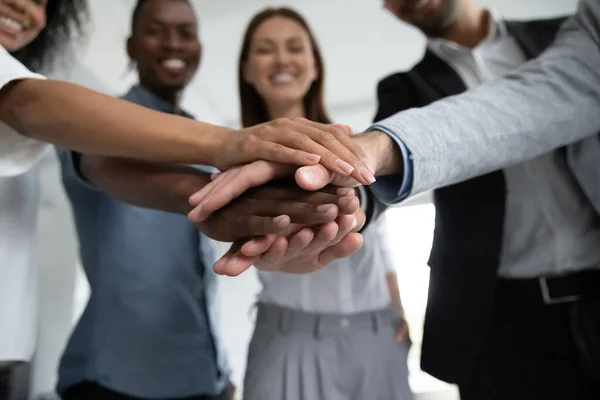 Närbild glada olika affärsmän att sätta händerna tillsammans. — Stockfoto