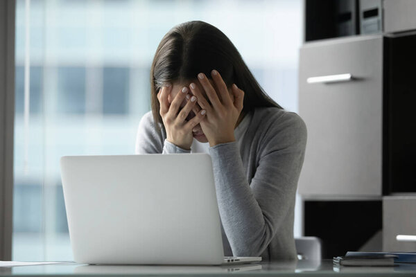 Anxious young woman suffer from health problems at workplace