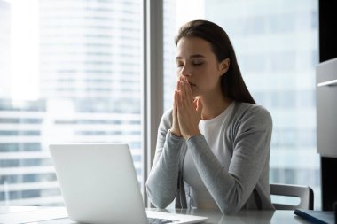 Dindar kadın çalışan işyerinde Tanrı 'ya dua ediyor.