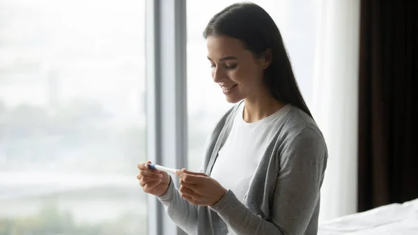 Friska kvinna känner sig glad få positiva graviditetstest resultat — Stockfoto