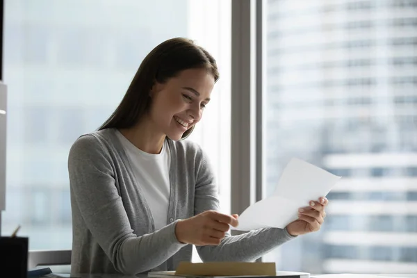 Une jeune femme souriante reçoit de bonnes nouvelles dans la correspondance postale — Photo