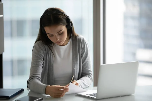 Focused woman in headphones watch webinar in office — Stock Photo, Image