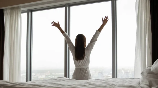 Happy young woman wake up stretching in morning — Stok Foto