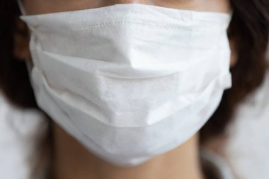 Tıbbi maske takan genç bir kadın. Koronavirüs salgını..