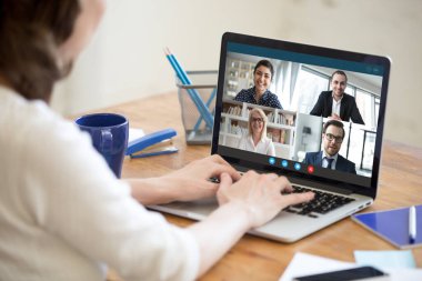 Evde çalışan bir kadın grup video görüşmesine katılıyor.