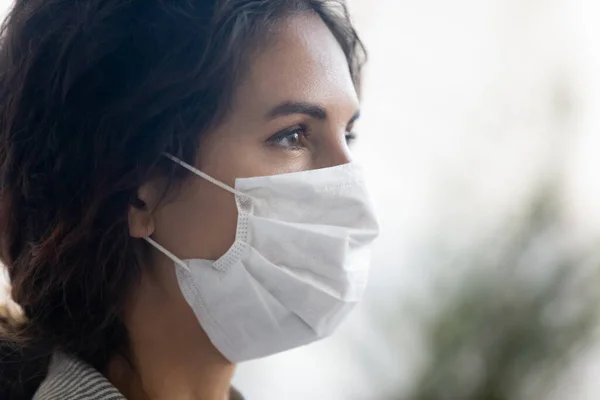Young woman wearing virus protection facial mask outside on street.