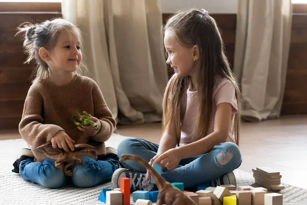 Adorable little kids sisters playing with toys in living room. — Stock Photo, Image