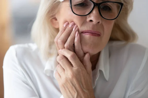 Close up 60 years old unhappy businesswoman having toothache. — Stock Photo, Image