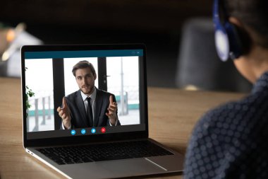 Kadın kulaklık takıyor. İnternetteki derste videoya kaydedilmiş hocaları dinliyor.