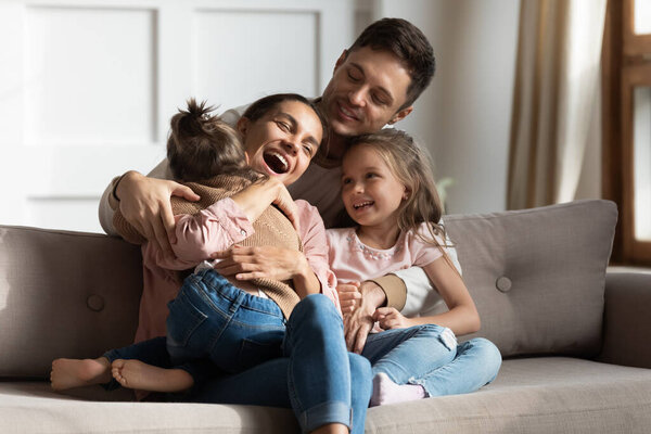 Счастливая семья веселится, сидя вместе на удобном диване
.