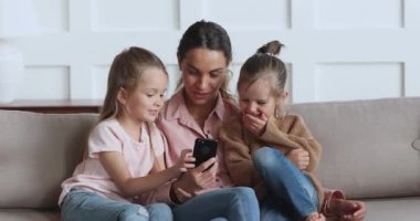 Genç ve güzel bir kadın küçük çocuklara komik videolar gösteriyor..