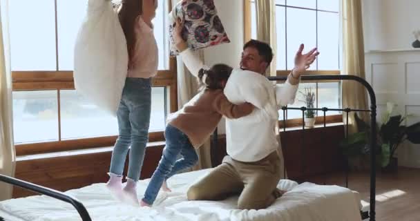 Jeune père excité combattant des oreillers avec de jeunes enfants riants . — Video