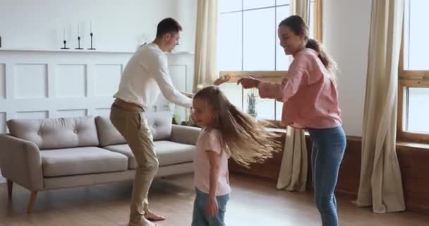 Happy father and mother dancing with small kids siblings. — Stock Video