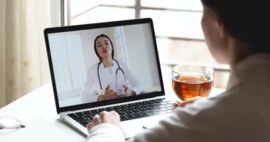 İnternetteki webcam görüntülü sohbetinde doktorla konuşan genç bir kadın.