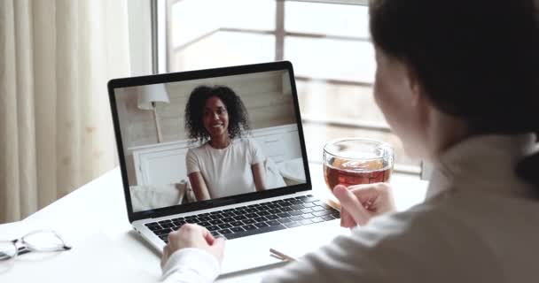 Mulher tendo conversa virtual com amigo africano, vista sobre o ombro — Vídeo de Stock