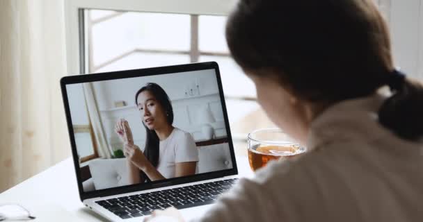 Young woman watching asian makeup artist tutorial on laptop screen — Stock Video