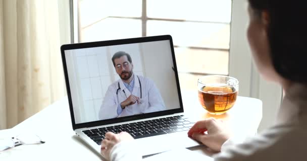 Médico masculino consultando paciente femenino en línea por videollamada webcam — Vídeo de stock