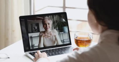 İki genç iş kadını video konferansında sohbet ediyorlar.
