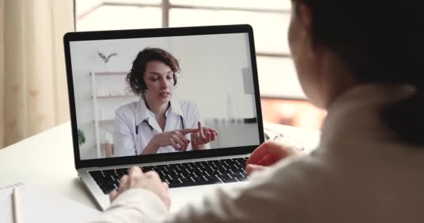 Kobieta terapeuta nosi słuchawki zapewniając pomoc medyczną w wirtualnym czacie — Wideo stockowe
