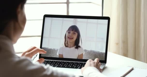 Онлайн-репетитор разговаривает с девочкой по видеозвонку с помощью компьютера — стоковое видео