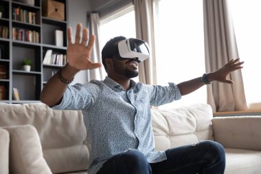 Overjoyed young guy enjoying spending time in virtual reality.