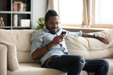 Smiling young biracial man using mobile applications.