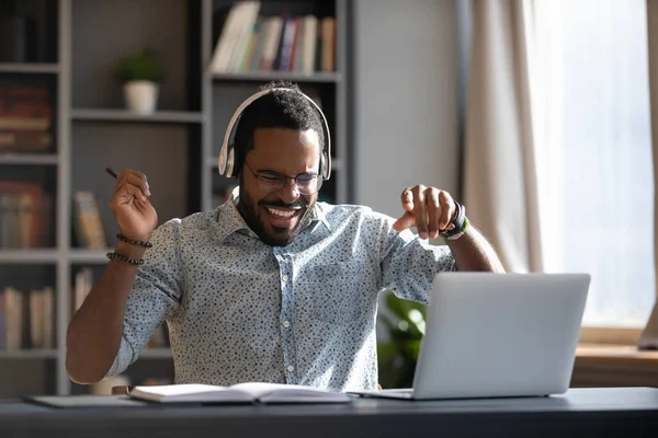 Glücklicher junger afrikanisch-amerikanischer Geschäftsmann genießt es, energiegeladene Musik zu hören. — Stockfoto