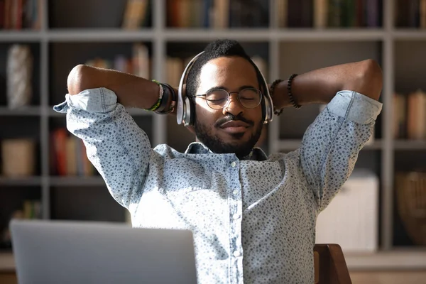Friedlicher junger afrikanisch-amerikanischer Geschäftsmann entspannt Klassik-Musik hören. — Stockfoto