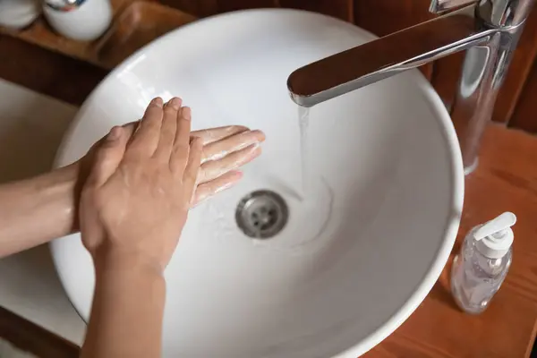Kobieta myje ręce mydłem nad umywalką, zbliżenie — Zdjęcie stockowe